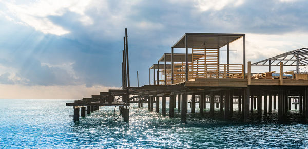 Pier over sea against sky during sunset