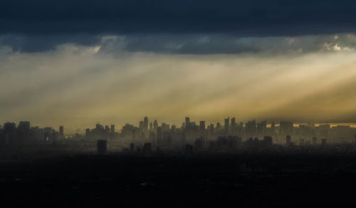 Silhouette buildings in city against sky