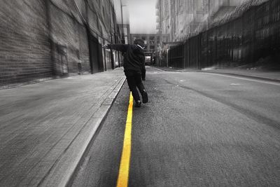 Rear view of man walking on road