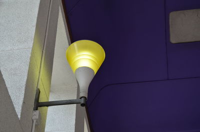 Low angle view of yellow light against wall