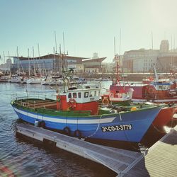 Boats moored at harbor against clear sky