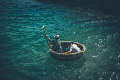 High angle view of men rowing on sea