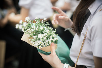 Midsection of woman holding flowering plant