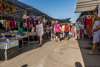 People at market stall against sky