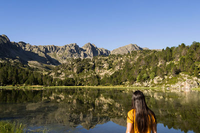 Rear view of woman in lake against clear sky