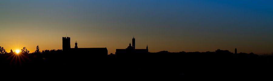 Silhouette buildings against sky during sunset