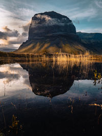 Scenic view of lake by mountain against sky