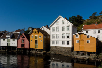 Buildings by river against sky