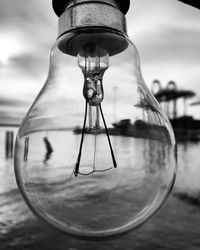 Close-up of light bulb against sea