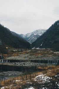 Scenic view of lake by mountains against sky