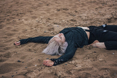 Man lying down on sand at beach