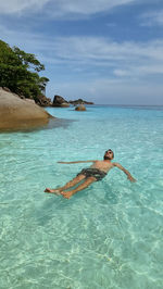 Man swimming in sea against sky