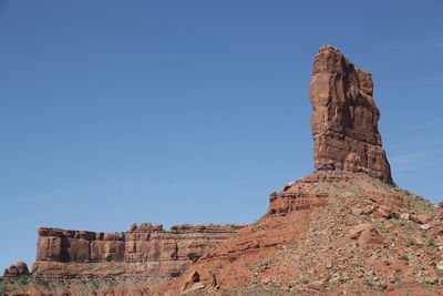 Low angle view of rock formation against clear blue sky