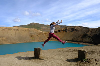 Woman jumping against sky