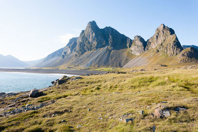 Scenic view of sea and mountains against clear sky