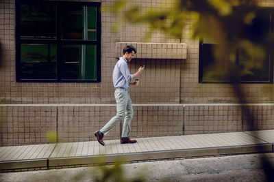 Full length of man standing against window