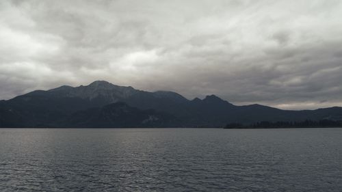 Scenic view of lake by mountains against sky