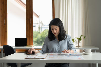 Young businesswoman working at desk in office