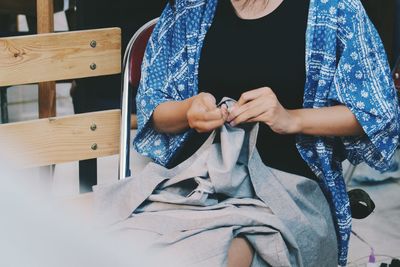 Midsection of woman sewing fabric