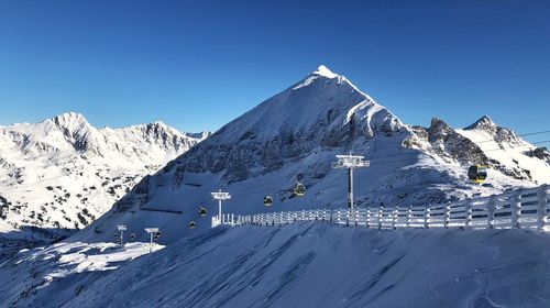 Snow covered mountain against clear blue sky