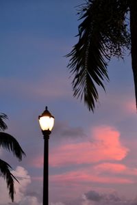 Low angle view of illuminated street light against sky at sunset