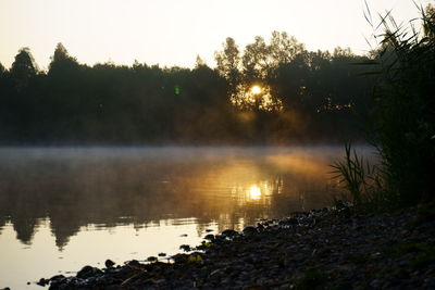 Scenic view of lake against sky during sunset