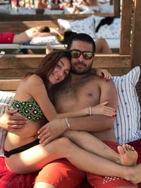 Portrait of couple sitting on sofa at beach