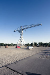 Titan crane by street against clear sky in city