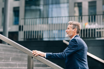 Side view of a man against building in city