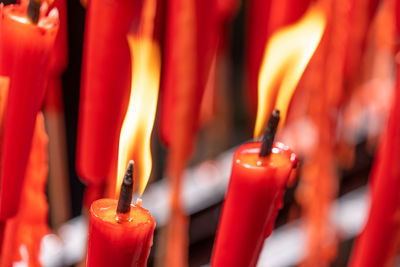 Rows of burning red candles are used in religious prayers