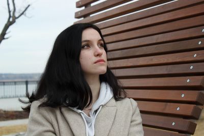 Young woman sits thoughtfully on the embankment