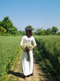 Rear view of woman standing on field