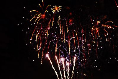 Low angle view of firework display at night