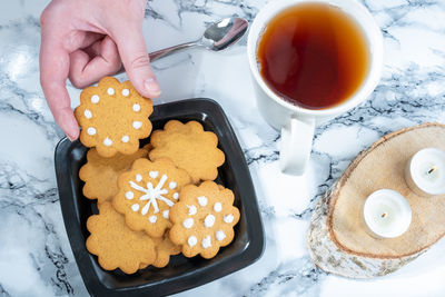 Overhead shot of a plate with homemade traditional finnish gingerbread cookies and a teacup.