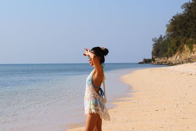 Woman on beach against clear sky