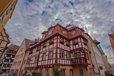 Low angle view of buildings against cloudy sky