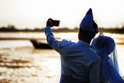 Rear view of man photographing