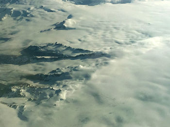 Aerial view of clouds over snow covered landscape