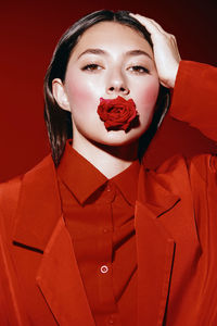 Portrait of young woman holding heart shape