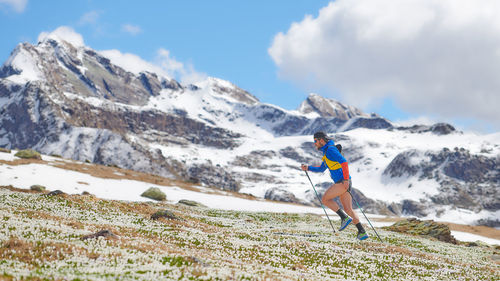 Trail athlete in the uphill mountains with sticks