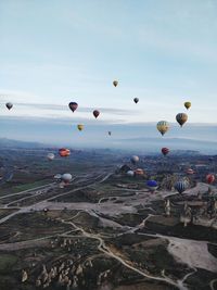 Hot air balloons flying over landscape