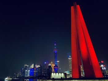 Illuminated modern buildings against clear sky at night