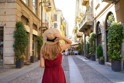 Stylish young woman walking in brera district, milan, italy