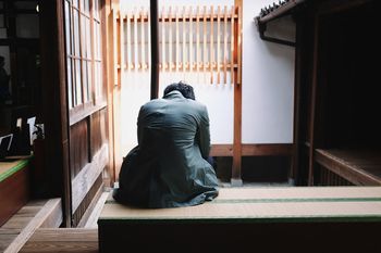 Rear view of man sitting on seat at home