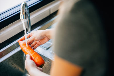 Midsection of woman holding thermometer