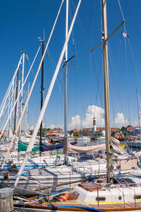 Sailboats moored at harbor against clear blue sky