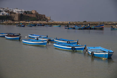 Boats moored at harbor in city