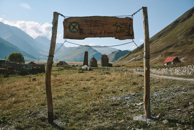 Information sign on field against sky