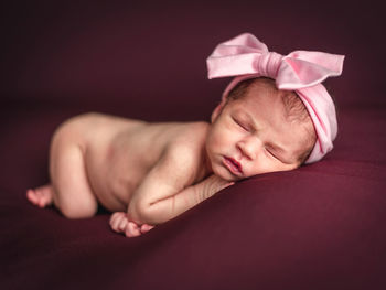 A newborn baby girl with a headband sleeping peacefully. newborn session concept