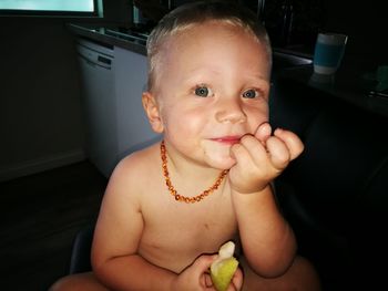 Portrait of cute boy having fruit at home
